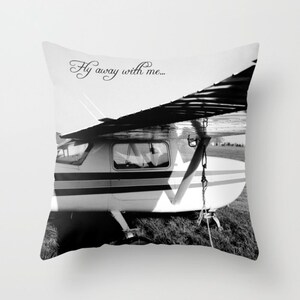 May include: Black and white photograph of a small airplane with the text "Fly away with me..." printed on the top of the image.