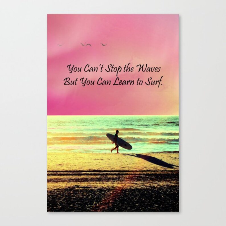 K&ouml;nnte beinhalten: Leinwanddruck mit einer Strandszene mit rosa und gelbem Himmel. Eine Person geht am Strand entlang und tr&auml;gt ein Surfbrett. Der Text lautet: "You Can't Stop the Waves But You Can Learn to Surf."
