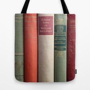 May include: Tote bag featuring a row of vintage books with titles including "Collected Stories of William Faulkner" and "Favorite Poems of Henry Wadsworth Longfellow." The books have various colors, including green, red, and beige, with gold lettering.