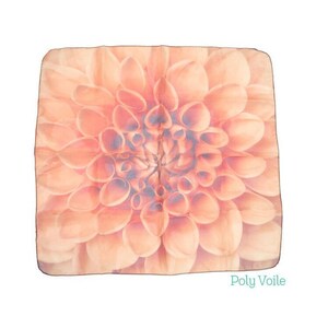 May include: A square peach-coloured silk scarf with a large, detailed floral print of a dahlia flower. The text "Poly Voile" is printed in the bottom right corner.