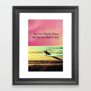 K&ouml;nnte beinhalten: Gerahmter Kunstdruck mit einem Strandmotiv und einem Surfer, der zum Meer geht. Der Himmel ist rosa und gelb, mit dem Text "You Can't Stop the Waves But You Can Learn to Surf."