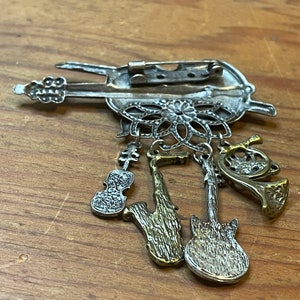 Musical themed charm brooch with multiple instruments