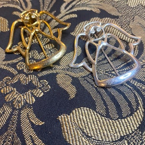 Set of two silver and gold tone angel brooches