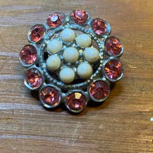 Broche de pedrería rosa y perlas artificiales