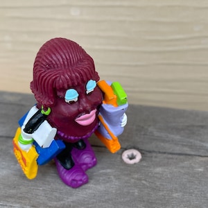 California Raisin Girl carrying bags including a Hardees bag