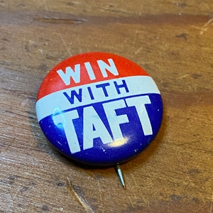 May include: A red, white, and blue button with the text "WIN WITH TAFT" in white letters.