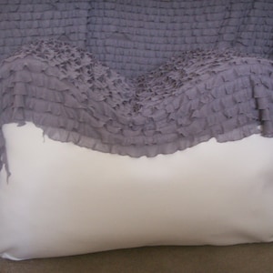 May include: A white beanbag chair covered with a gray ruffled fabric.