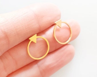 May include: A pair of gold-toned earrings with a small triangle shape at the top of each circle.