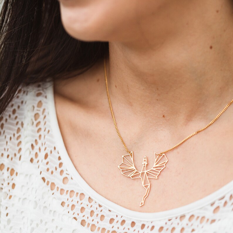 Puede incluir: Un collar de oro con un colgante de drag&oacute;n geom&eacute;trico. El drag&oacute;n est&aacute; hecho de metal fino y tiene un dise&ntilde;o delicado e intrincado.
