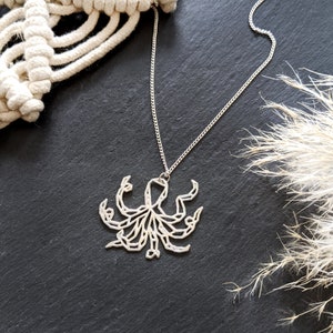 May include: A silver necklace with an octopus pendant. The octopus is made of geometric shapes and has a detailed design.
