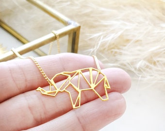 May include: A gold-toned necklace with a geometric origami elephant pendant. The pendant is made of thin metal and has a delicate, intricate design.