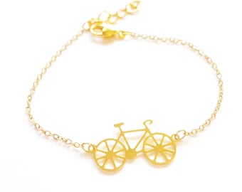 Pulsera dorada con dije de bicicleta: joyería urbana delicada