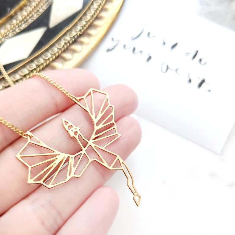 Puede incluir: Collar de oro con un colgante de drag&oacute;n geom&eacute;trico. El colgante est&aacute; hecho de metal fino y tiene un dise&ntilde;o delicado e intrincado.
