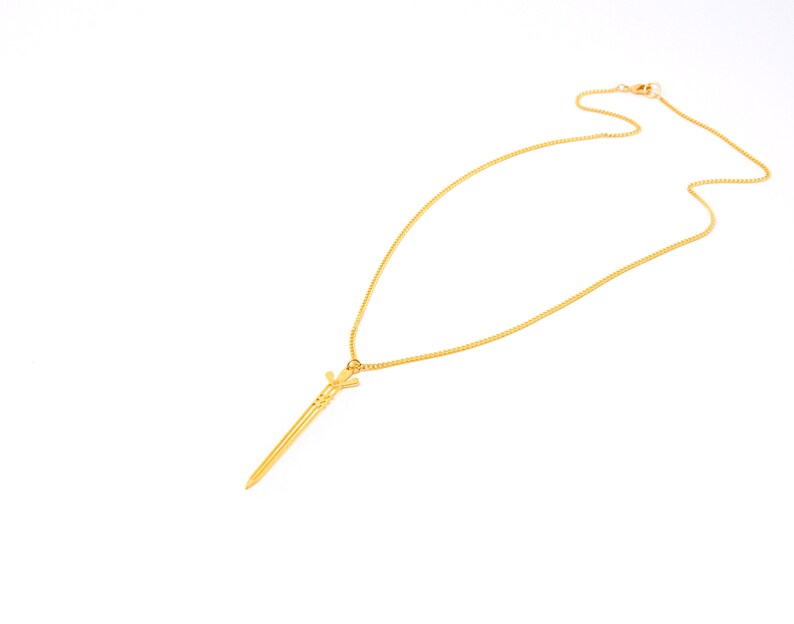May include: A gold chain necklace with a sword pendant.