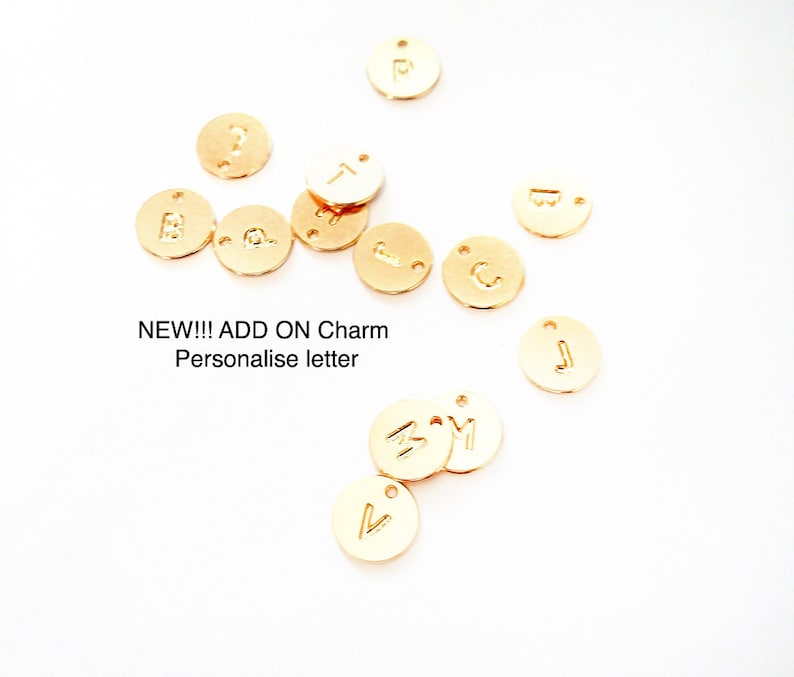 May include: Gold-colored metal letter charms with a variety of letters, including A, B, C, J, M, P, T, and V.  NEW!!! ADD ON Charm Personalise letter