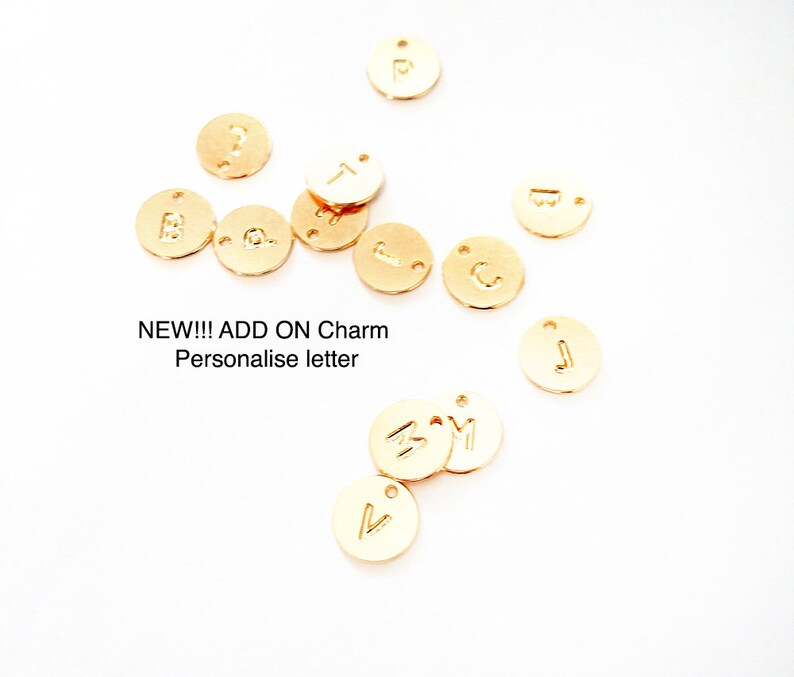 May include: Gold-coloured metal letter charms with a variety of letters, including A, B, C, J, M, P, T, and V.  NEW!!! ADD ON Charm Personalise letter
