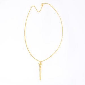 May include: A gold chain necklace with a sword pendant.