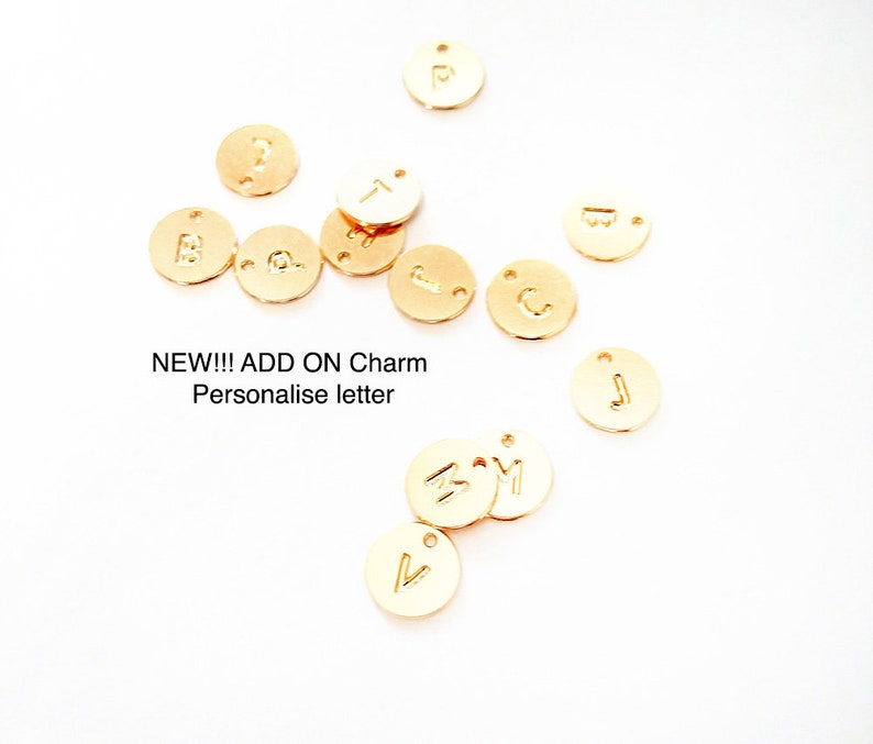 May include: Gold-colored metal letter charms with a variety of letters, including A, B, C, J, M, P, T, and V.  NEW!!! ADD ON Charm Personalise letter