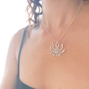 May include: A silver necklace with an octopus pendant. The octopus is made of wire and has a detailed design.