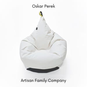 Op de afbeelding: Witte zitzak met een zwarte basis en een gele en zwarte trekband. De zitzak is gelabeld met "Oskar PereK" en "Artisan Family Company".