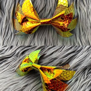 May include: A large gold bow with a honeycomb pattern. The bow is made of iridescent material and has a slightly 3D effect.