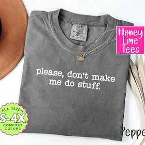 May include: A gray Comfort Colors t-shirt with the text "please, don't make me do stuff" in white. The shirt has a crew neck and short sleeves. A gold necklace is draped on the shirt. The shirt is available in sizes S-4X.