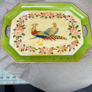 May include: Vintage decorative tray with a green and gold octagonal frame. The tray features a cream-colored center with a floral border and two pheasant illustrations. The tray has two handles and is a unique piece of home decor.