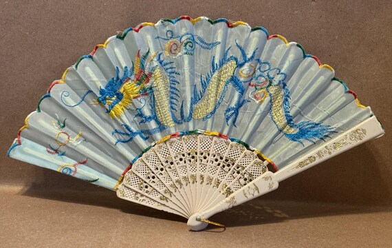 Vintage dime store fabric and plastic embroidered fan with dragon designs