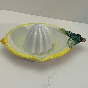 vintage ceramic dime store orange juicer decorated like and orange with leaf.