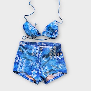 Może przedstawiać: Niebieski bikini w białe kwiaty z gorsetem i wysokim stanem.