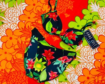 May include: Black bikini with a floral print. The top has adjustable straps and a hook closure. The bottom is a high-waisted style. The bikini is on a colorful background with a pineapple pattern.