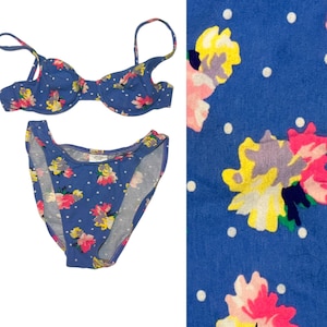 May include: A blue floral print bikini with white polka dots. The bikini top has underwire and adjustable straps. The bikini bottom is a high-cut style.