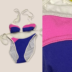 May include: A white, pink, and blue striped bikini with a halter top and high-cut bottoms.