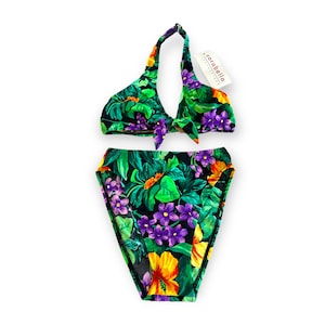 May include: A green, black, yellow, and purple floral print bikini top and bottom. The bikini top has a halter style with a tie at the neck. The bikini bottom is a high-waisted style. The brand label reads "carabella".