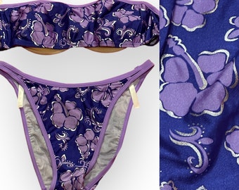 May include: Purple and blue bikini with a floral print. The top is strapless and the bottom is a high-cut style.