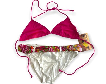 May include: A pink bikini top with a white bottom. The bottom has a colorful floral print around the waistband.