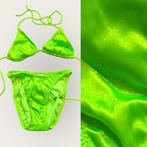 Puede incluir: Un bikini de color verde neón, con parte superior y parte inferior. La tela es brillante y tiene un ligero brillo.