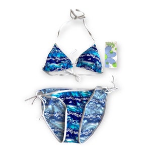 Puede incluir: Bikini azul y blanco con estampado de palmeras. La parte superior del bikini es de estilo triangular con tirantes ajustables. La parte inferior del bikini es de estilo de corte alto con lazos a los lados.