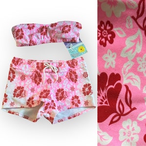 May include: Pink and red floral print bikini top and shorts. The top is strapless and the shorts have a drawstring waist.