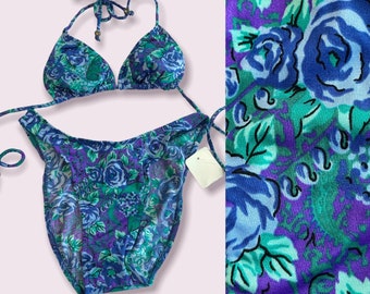 May include: A blue and green floral print bikini top and bottom. The top is a triangle style with adjustable straps. The bottom is a high-cut style with ties on the sides.