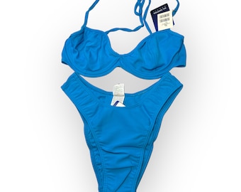 May include: A bright blue bikini set. The top has a halter neck design, and the bottoms are high-cut. The set is made of a smooth fabric and includes tags. A classic swimwear item.