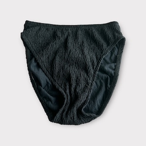 May include: Black textured bikini bottom with a high-cut leg.