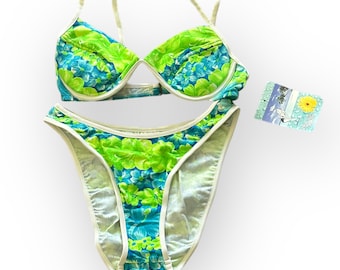 May include: A green and blue floral print bikini with white trim. The bikini top has a halter style strap and the bottom is a high-cut style.