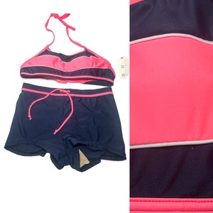 May include: A two-piece swimsuit with a halter top and shorts. The top is pink and navy blue striped with a white stripe. The shorts are navy blue with a pink trim. The tag says "QUA"