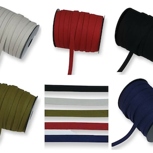 May include: Six spools of fabric trim in various colours, including white, red, black, green, navy blue, and a close-up of the spools showing the colours in a row. The trim is a flat, woven fabric with a slightly textured surface.