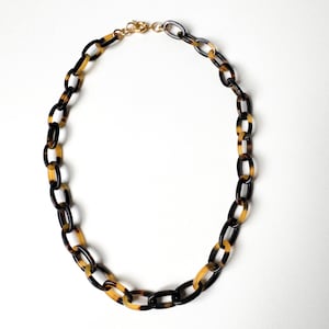 May include: A set of three ceramic mugs with a speckled, matte finish. The mugs are in shades of cream, light gray, and dark gray. Each mug has a simple, minimalist design, perfect for coffee or tea.