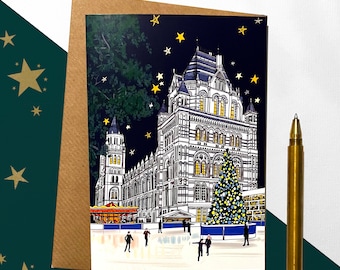 May include: A Christmas card featuring a black and white illustration of the Natural History Museum in London with a Christmas tree and an ice skating rink in front of it. The illustration is set against a dark blue background with gold stars.