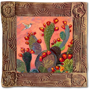 May include: A framed painting of a hummingbird flying over a cactus with pink flowers. The frame is gold with intricate designs.