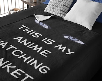 May include: Black fleece blanket with white text that reads "This is my anime watching blanket" and a pair of blue eyes printed on the blanket.