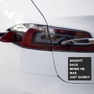 May include: A white car with a black bumper sticker that reads "Bought back when he was just quirky".